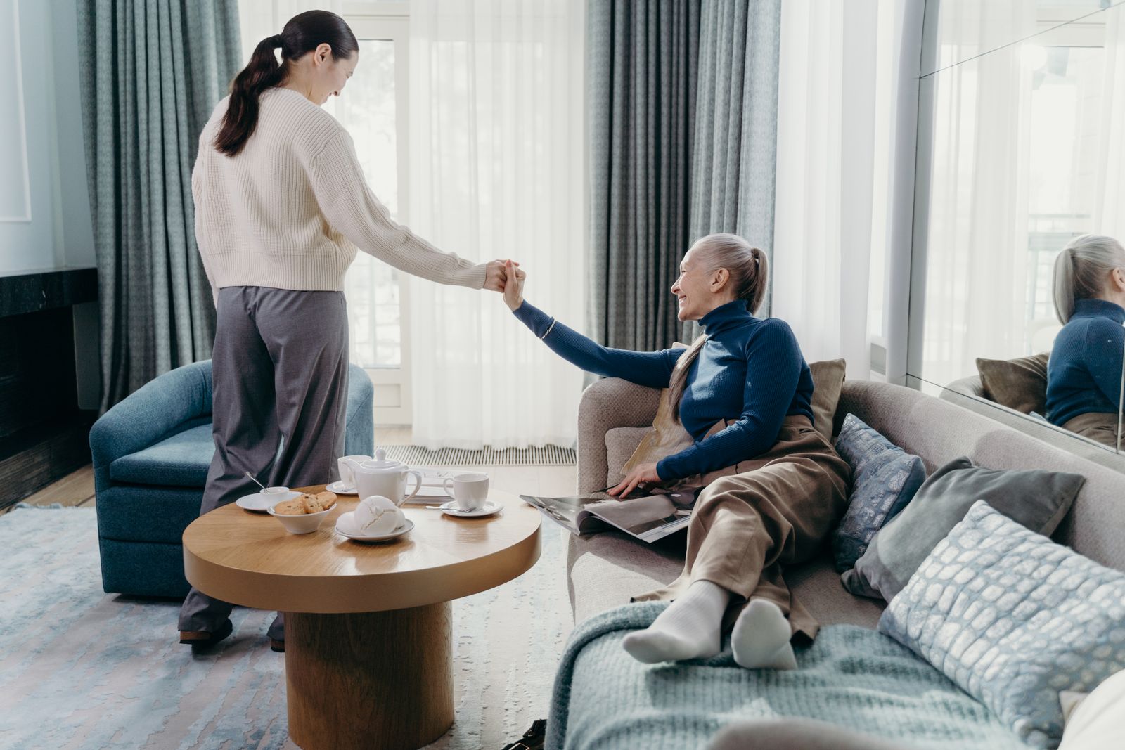 Deux générations réunies à la maison, une main tendue entre elles.